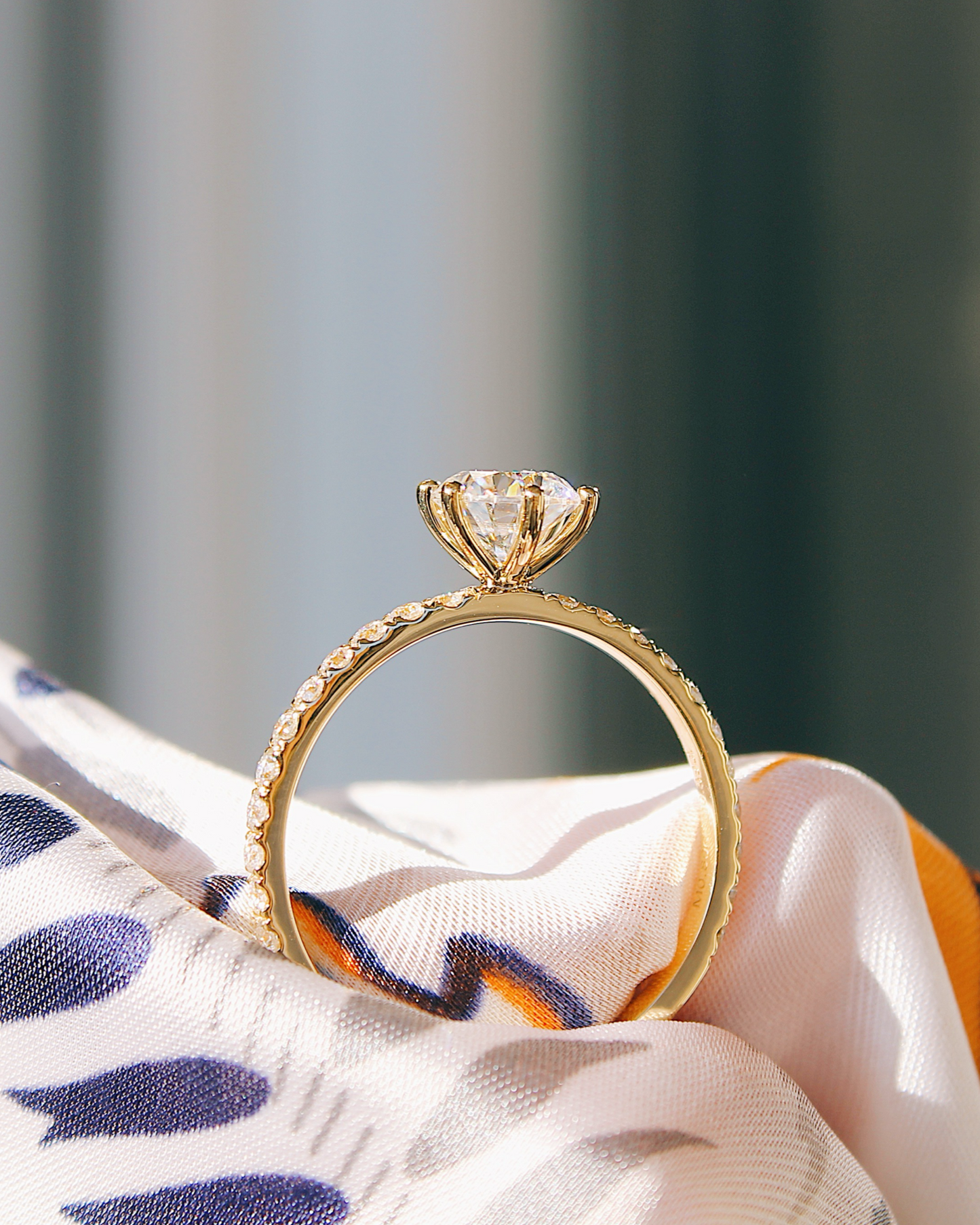 Delia - 18K Gold Verlobungsring mit Round Brillinat Cut und pavébesetzter RIngschiene, Seitenansicht mit Fassung