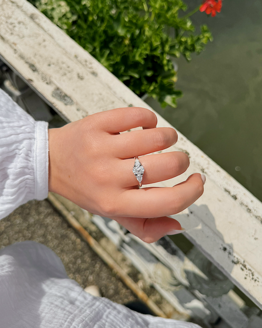 Nola - 18K Gold Trilogy Ring mit Oval Cut Mittelstein und zwei pear Cut Seitensteinen, getragen an der Hand