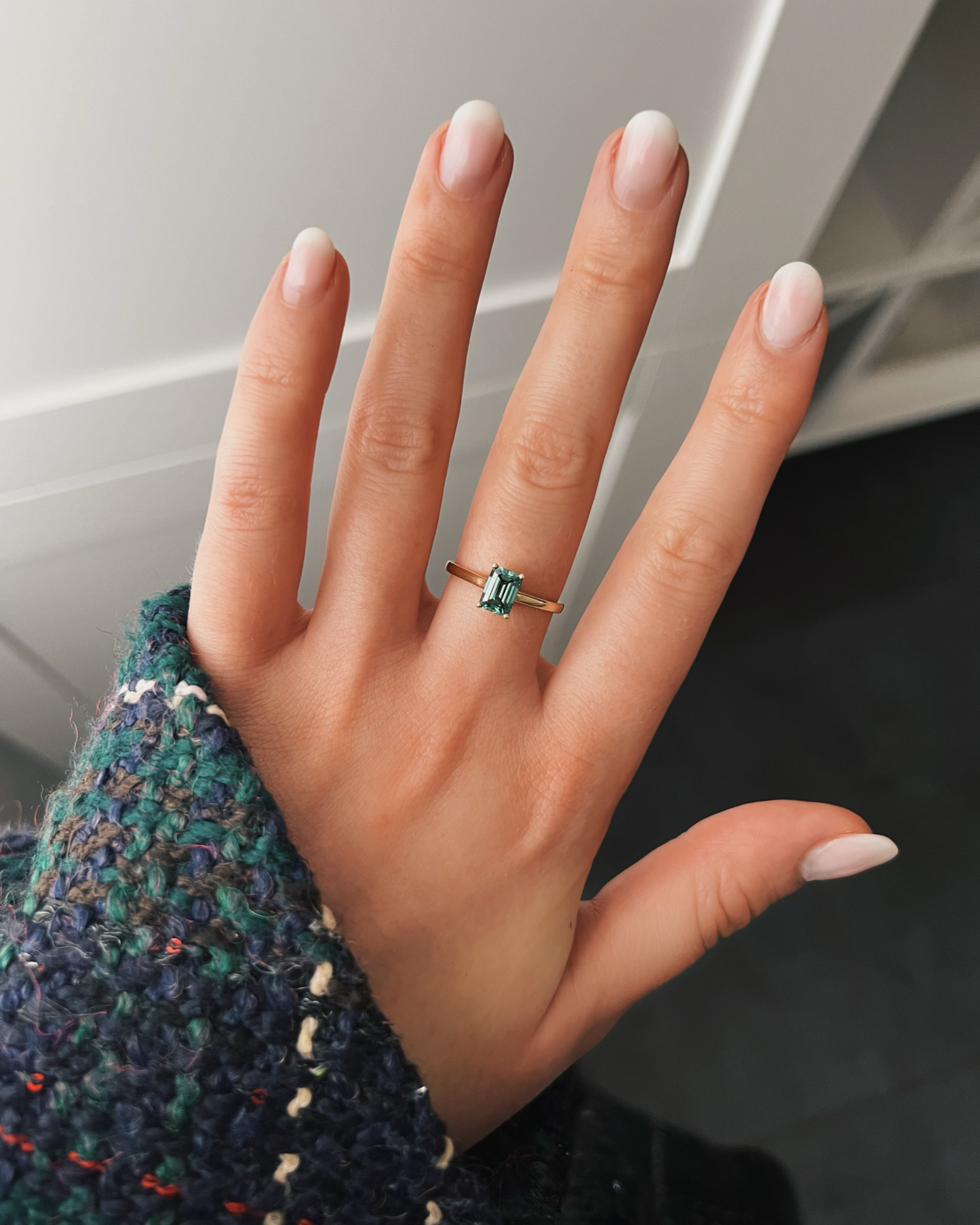 Malu - 18K Gelbgoldring mit einem grünen Lab Grown Diamanten oder Moissaniten im Emerald Cut, getragen an der Hand