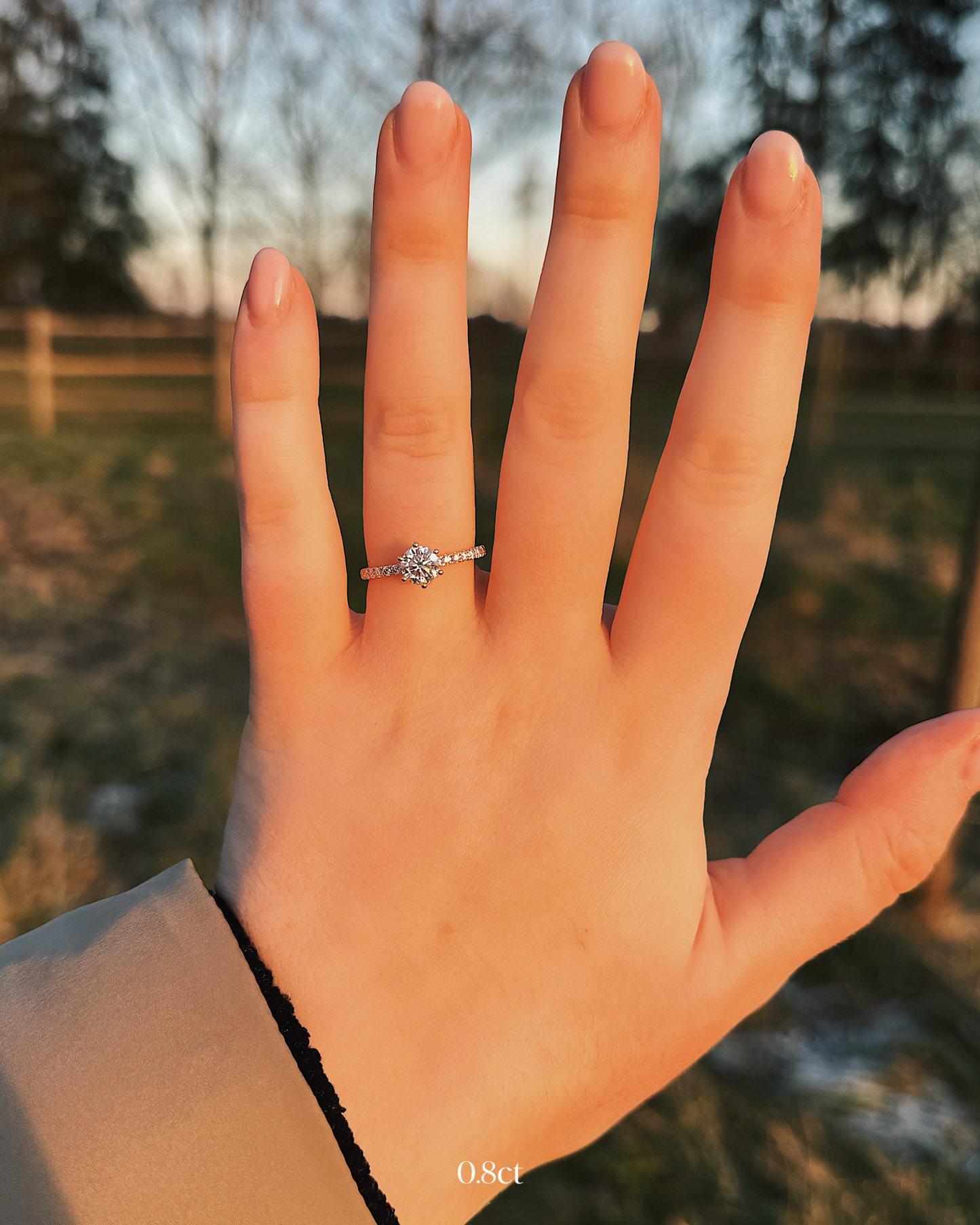 Delia - 18K Gold Verlobungsring mit Round Brillinat Cut und pavébesetzter RIngschiene, getragen an der Hand